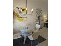 Dining room showcasing a glass table, wicker base, chairs, and modern light fixture at 1414 58Th W St # 1414, Bradenton, FL 34209