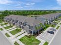 Aerial view of townhomes showcasing landscaping, parking, and proximity to community pond at 15051 Ginetti St, Nokomis, FL 34275