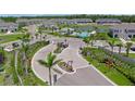 Aerial view of the community entrance and pool with lush landscaping at 15051 Ginetti St, Nokomis, FL 34275