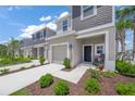 Inviting townhome showcasing a one-car garage, walkway, and pleasant landscaping at 15051 Ginetti St, Nokomis, FL 34275