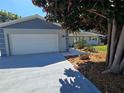 Attached two-car garage with a concrete driveway and beautifully landscaped front yard at 2204 34Th W St, Bradenton, FL 34205
