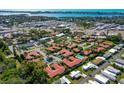 Aerial view of residential community with community pool, lush trees and water views in the distance at 2259 Pueblo Ln # V38, Sarasota, FL 34231