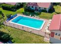 Aerial view of community pool with fence and lounge chairs surrounded by green space and buildings at 2259 Pueblo Ln # V38, Sarasota, FL 34231