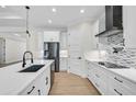 Bright kitchen with white cabinets, stainless steel appliances, and mosaic backsplash at 260 Marker Rd, Rotonda West, FL 33947