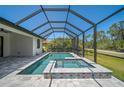 Stunning screened-in pool and jacuzzi surrounded by a beautiful view of nature at 260 Marker Rd, Rotonda West, FL 33947