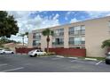 Exterior view of multi-Gathering condo with black wrought iron balconies and tan paint scheme at 2763 Woodgate Ln # 210, Sarasota, FL 34231