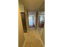 Hallway leading to living area with tile floor and mirror accent at 2763 Woodgate Ln # 210, Sarasota, FL 34231