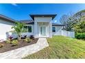 Welcoming entrance with stone walkway, pretty landscaping, and a covered porch at 380 Holly Rd, Venice, FL 34293