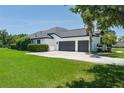 View of the garage with grey doors and lush front yard at 3806 155Th E Ave, Parrish, FL 34219
