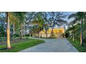 View of home with a large driveway framed by lush trees and landscaping at 4123 Bay Shore Rd, Sarasota, FL 34234