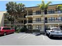 Condo building with three stories, black railings and tropical foliage at 425 30Th W Ave # C204, Bradenton, FL 34205