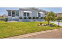 Well-manicured lawn with tidy shrubbery in front of a light blue single-story home at 4519 14Th E St, Ellenton, FL 34222