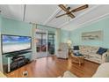 Bright living room features hardwood flooring, ceiling fan, and access to a screened lanai at 4519 14Th E St, Ellenton, FL 34222