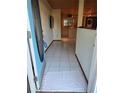 Entryway with light blue door, white tile flooring, and view into the open concept kitchen at 4700 Neptune Rd, Venice, FL 34293