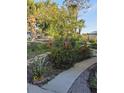 Landscaped front yard with mature trees and flowering shrubs along a walkway to the house at 4700 Neptune Rd, Venice, FL 34293