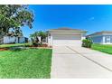 Inviting single-Gathering home showcasing a well-maintained lawn, a concrete driveway, and an attached garage at 5102 98Th E Ave, Parrish, FL 34219