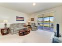 Comfortable living room with neutral carpet, sliding glass doors to a screened patio, and serene water views at 5102 98Th E Ave, Parrish, FL 34219