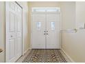 Bright foyer features a decorative glass double door and tile flooring at 6110 Misty Oaks St, Sarasota, FL 34243