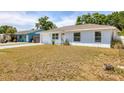 A single-story home with a tidy lawn and attached garage, set against a backdrop of lush greenery at 6611 2Nd Ne Ave, Bradenton, FL 34208