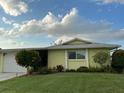 Single-story home with well-manicured lawn, blue sky and lovely landscaping at 6902 11Th W Ave, Bradenton, FL 34209
