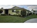 Manicured front yard with lush green lawn, landscaping and pretty trees at 6902 11Th W Ave, Bradenton, FL 34209