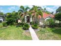 Beautiful home featuring lush landscaping, stately palm trees and a red tile roof at 8005 Royal Birkdale Cir, Lakewood Ranch, FL 34202