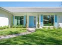 Inviting front entrance with bright blue door, manicured landscaping, and freshly cut green grass at 172 Sea Anchor Dr, Osprey, FL 34229
