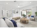 Bright, open-concept living area featuring white furnishings, marble floors, and access to an outdoor patio at 172 Sea Anchor Dr, Osprey, FL 34229