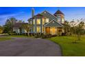 Charming two-story home boasts a turret, manicured lawn, and inviting curb appeal with a circular driveway at 19006 69Th E Ave, Bradenton, FL 34211