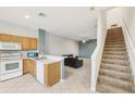 Open-concept living space with tile floors, stairs, and a combined kitchen and living room at 2353 Rosewood Ln, North Port, FL 34289