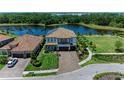 Beautiful two-story home with a tile roof, brick driveway, manicured lawn and beautiful lake views at 2806 Starwood Ct, Lakewood Ranch, FL 34211