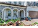 Charming front porch with stone accents, arched entry, rocking chairs, and lush landscaping at 2806 Starwood Ct, Lakewood Ranch, FL 34211