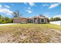 A tan single-story home with a two-car garage and solar panels is accented by bright-white trim and fresh landscaping at 3453 Dryden St, North Port, FL 34288