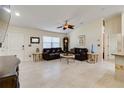 Bright living room boasting tile floors, vaulted ceilings, a ceiling fan, and comfortable dark-brown leather furniture at 3453 Dryden St, North Port, FL 34288