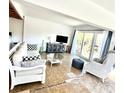 Living room with comfy seating, decorative guitar, and water view through glass doors at 36 N Starboard Dr, Venice, FL 34285