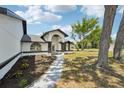 Beautifully landscaped single-story house with a gray walkway leading to an arched entryway at 4265 Hoffman Ave, Spring Hill, FL 34606