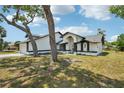 Single-story home features unique architecture, manicured landscaping, and mature trees on an expansive lawn at 4265 Hoffman Ave, Spring Hill, FL 34606