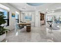 Open-concept living area with marble floors, desk, and chandelier at 50 Central Ave # 17Phd, Sarasota, FL 34236
