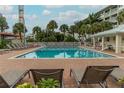 Relaxing pool area with lounge chairs, palm trees, and clear blue water for a serene outdoor experience at 6610 Midnight Pass Rd # 11, Sarasota, FL 34242