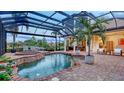 Screened pool area featuring a spa, brick-paver decking, and a tropical palm tree at 6819 Dominion Ln, Lakewood Ranch, FL 34202