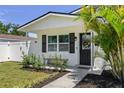 Welcoming front entry featuring a decorative door and a bench surrounded by meticulously maintained landscaping at 7141 37Th N Ave, St Petersburg, FL 33710