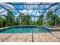 Enjoy the outdoors with a screened-in pool and spa featuring elegant tiling and a beautiful view at 749 Tailwind Pl, Sarasota, FL 34240