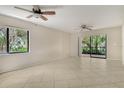 Bright living room with tile floors, ceiling fan, and sliding doors to a beautiful outdoor patio at 7876 Eagle Creek Dr, Sarasota, FL 34243