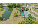 Beautiful aerial view of home with pool and adjacent pond, surrounded by lush greenery at 7912 Estates Dr, Sarasota, FL 34243