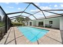 An inviting in-ground pool sits within a screened enclosure, offering a private outdoor retreat with ample seating at 7912 Estates Dr, Sarasota, FL 34243