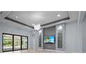 Living room area with sliding glass doors, custom shelving, and modern lighting at 8229 Grande Shores Dr, Sarasota, FL 34240