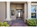 Inviting front entrance with decorative glass door, brick walkway, and white pillars at 8297 Barton Farms Blvd, Sarasota, FL 34240