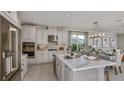 Modern kitchen featuring stainless steel appliances, a large island, white cabinets, and an adjacent dining area at 8579 Big Dipper Dr, Sarasota, FL 34241