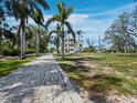 Paver driveway leading to a stunning multi-level home surrounded by lush tropical landscaping at 9315 9Th Nw Ave, Bradenton, FL 34209