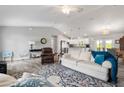 Spacious open-concept living room with vaulted ceilings, neutral walls, and wood-look tile flooring at 9601 Calumet Blvd, Port Charlotte, FL 33981
